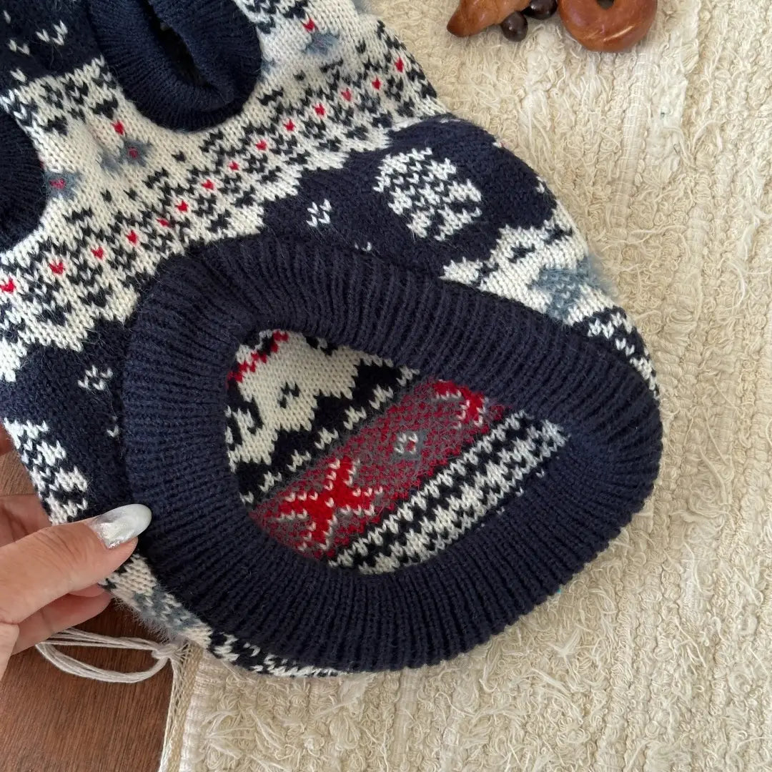 Pull en tricot nordique pour chien bleu marine, blanc et rouge, avec un motif traditionnel, conçu comme vêtement d’hiver chaud pour animaux de compagnie.