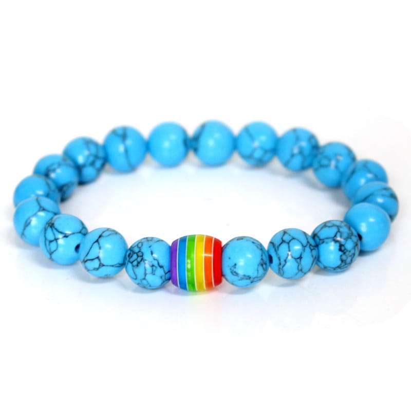 A vibrant turquoise natural stone beaded bracelet featuring a central rainbow-striped pride accent bead.