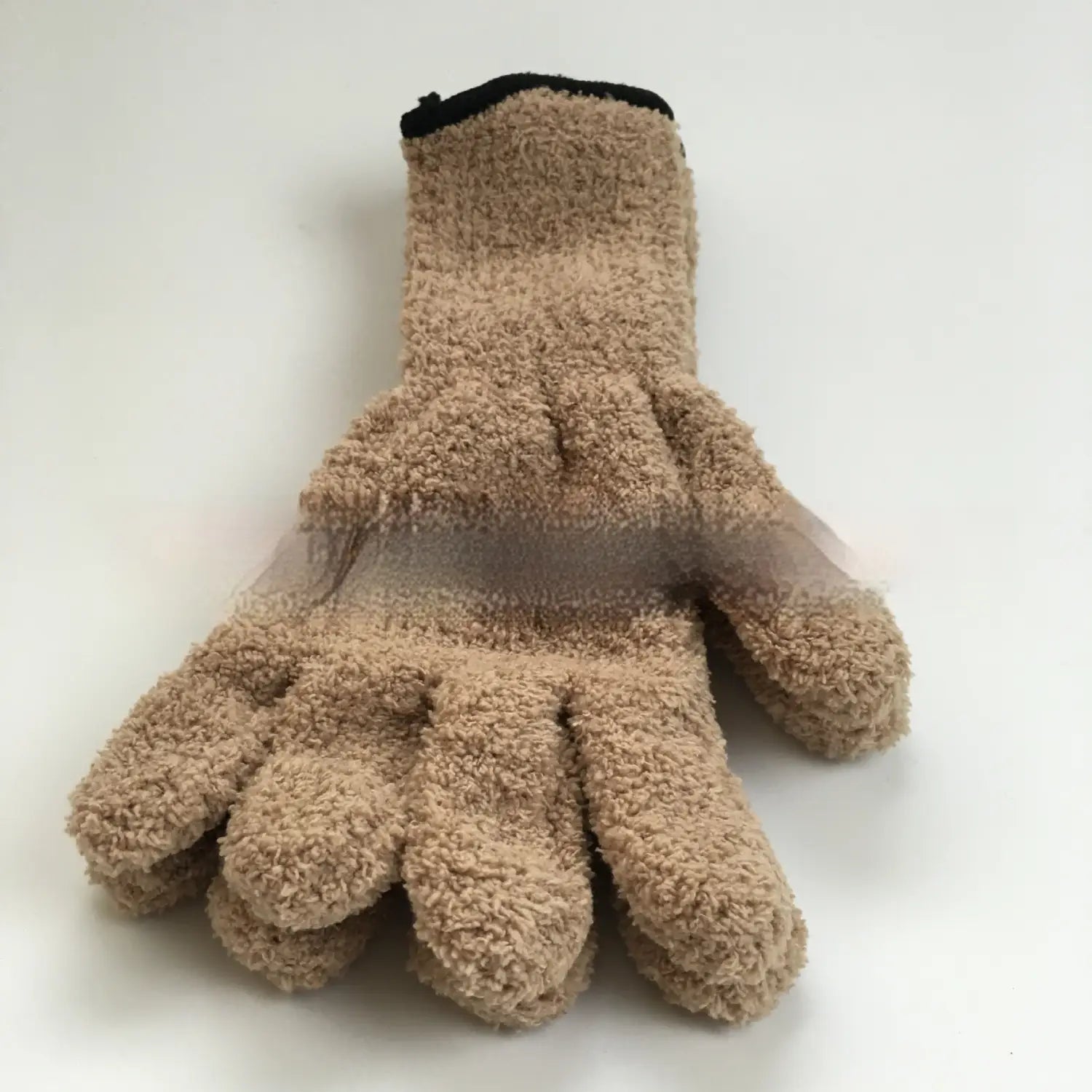 Tan plush coral fleece bath dust glove shown from the back with a black cuff and transparent mesh panel on the back of the hand.