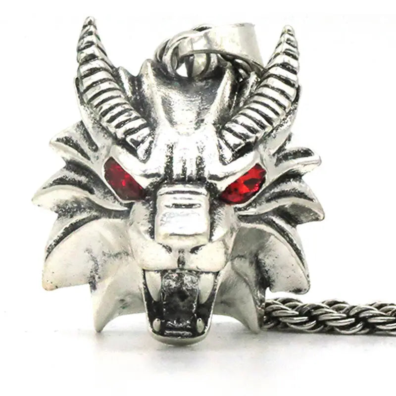 Silver dragon head pendant with red gemstone eyes and textured metallic finish attached to a twisted chain in a geometric wild game animal pendant chain necklace.