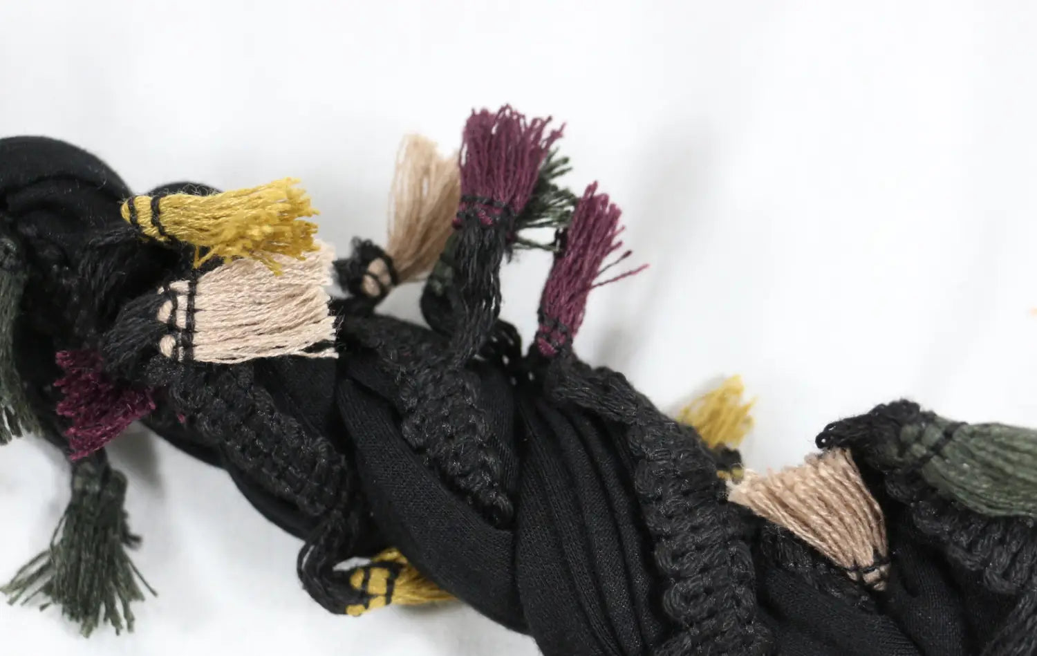 Men satin lined beard twist cap made of black woven fabric scarf featuring colorful tassels in maroon yellow beige and green.