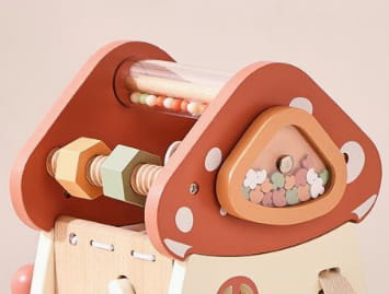 Jouet en bois en forme de champignon issu de la série de jouets pour cube d’activités en bois à 5 en 1, présentant un corps orange doux avec des pois blancs et des perles colorées à l’intérieur de son capuchon triangulaire.