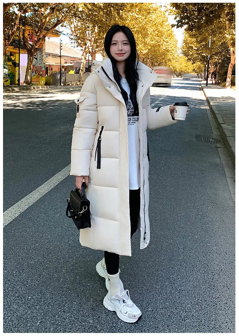 Cremefarbene koreanische gesteppte Pufferjacke mit Kapuze aus Daunen, mit hohem Kragen und schwarzen Reißverschluss-Zuglaschen.