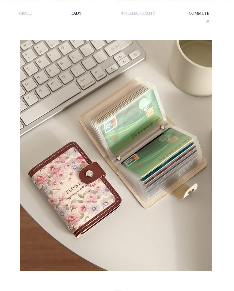 Vintage floral leather card holder wallet featuring a compact design with a pink blossom floral pattern on an off-white background, secured by a brown leather strap and silver-toned clasp.