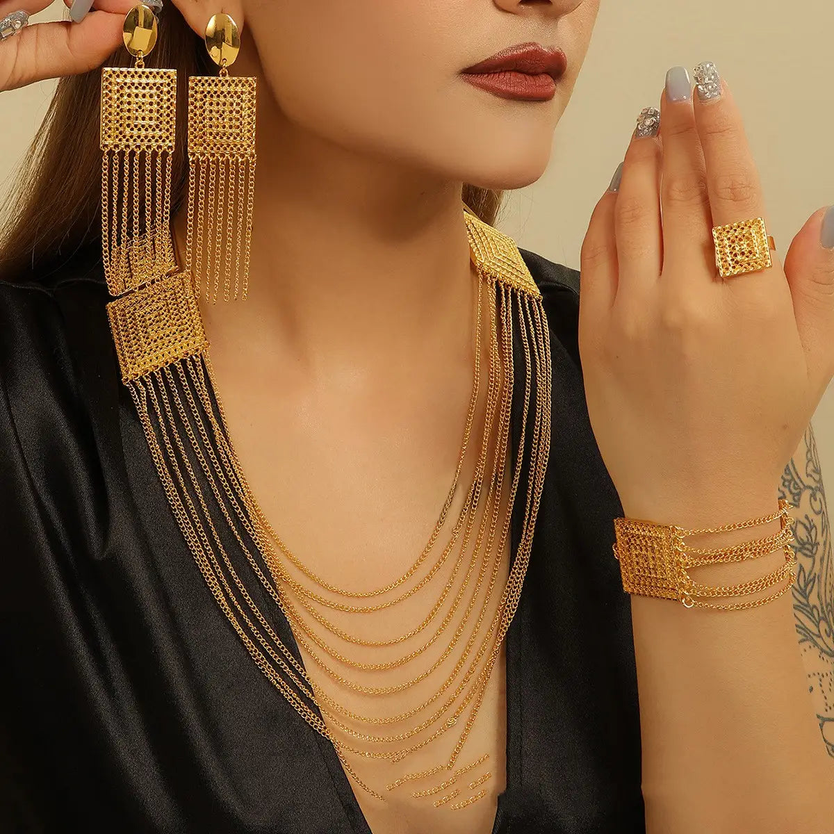 gold-toned layered tassel necklace featuring geometric mesh square accents and dangling fringe as part of a jewelry set