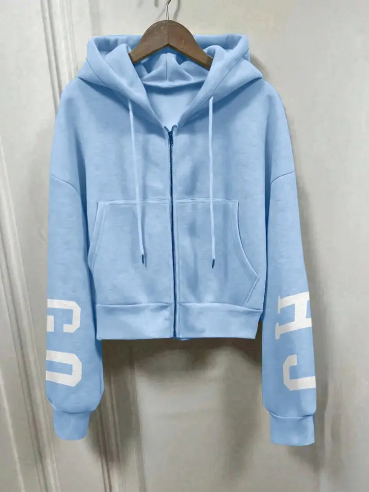 Hoodie zippé court bleu clair imprimé graphique, avec des lettres blanches sur les manches provenant de la collection de sweat-shirts à capuche zippés imprimés graphiques.
