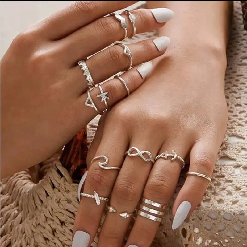a bohemian silver mixed motif stackable ring set featuring silver-toned rings with anchor infinity star and geometric designs