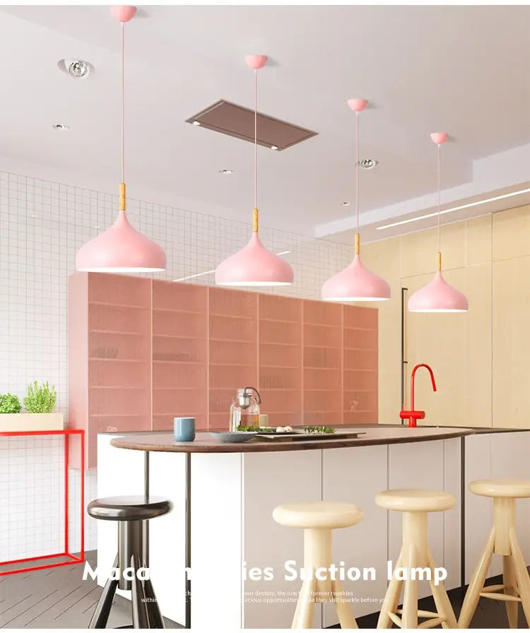 pink conical nordic macaron led pendant lamps with gold-toned fixtures and wood accents hang from the ceiling.