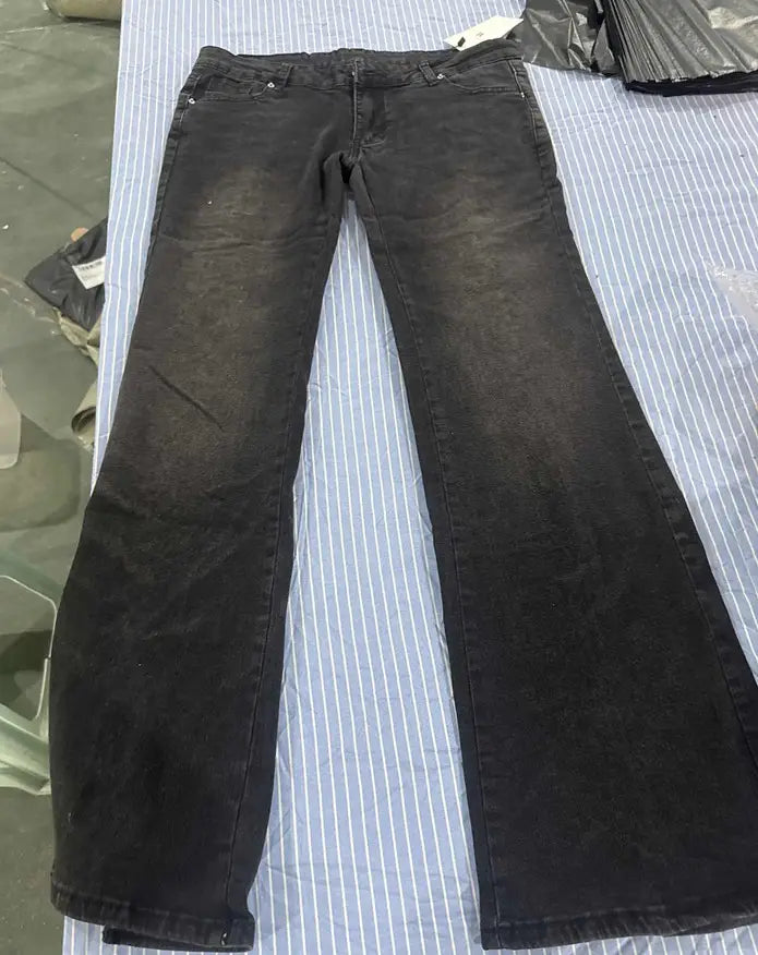 Jeans de mezclilla de tiro bajo tipo campana en denim negro con un aspecto descolorido y desgastado, y desvanecimiento sutil en los muslos.