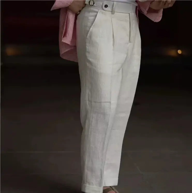 White high waisted linen trousers for men with a pleated front design.