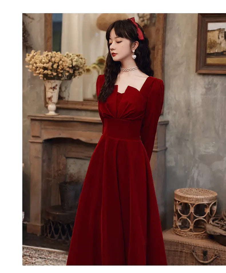 a rich burgundy velvet gown featuring a square neckline and long sleeves in an a-line silhouette