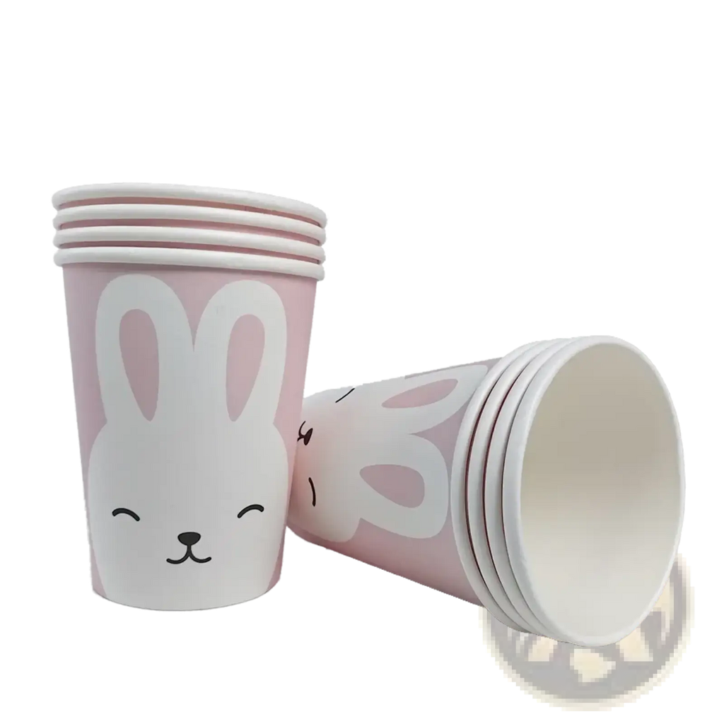 Pink paper cups with white bunny faces and black whiskers from the Easter Bunny paper plates and cups set