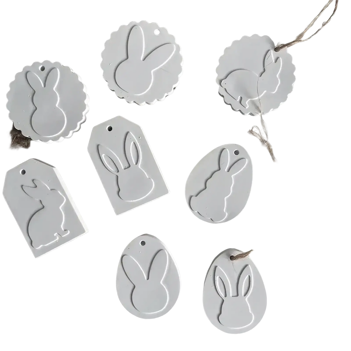 White ceramic easter bunny-shaped tags with scalloped edges and loops made using easter bunny silicone pendant mold