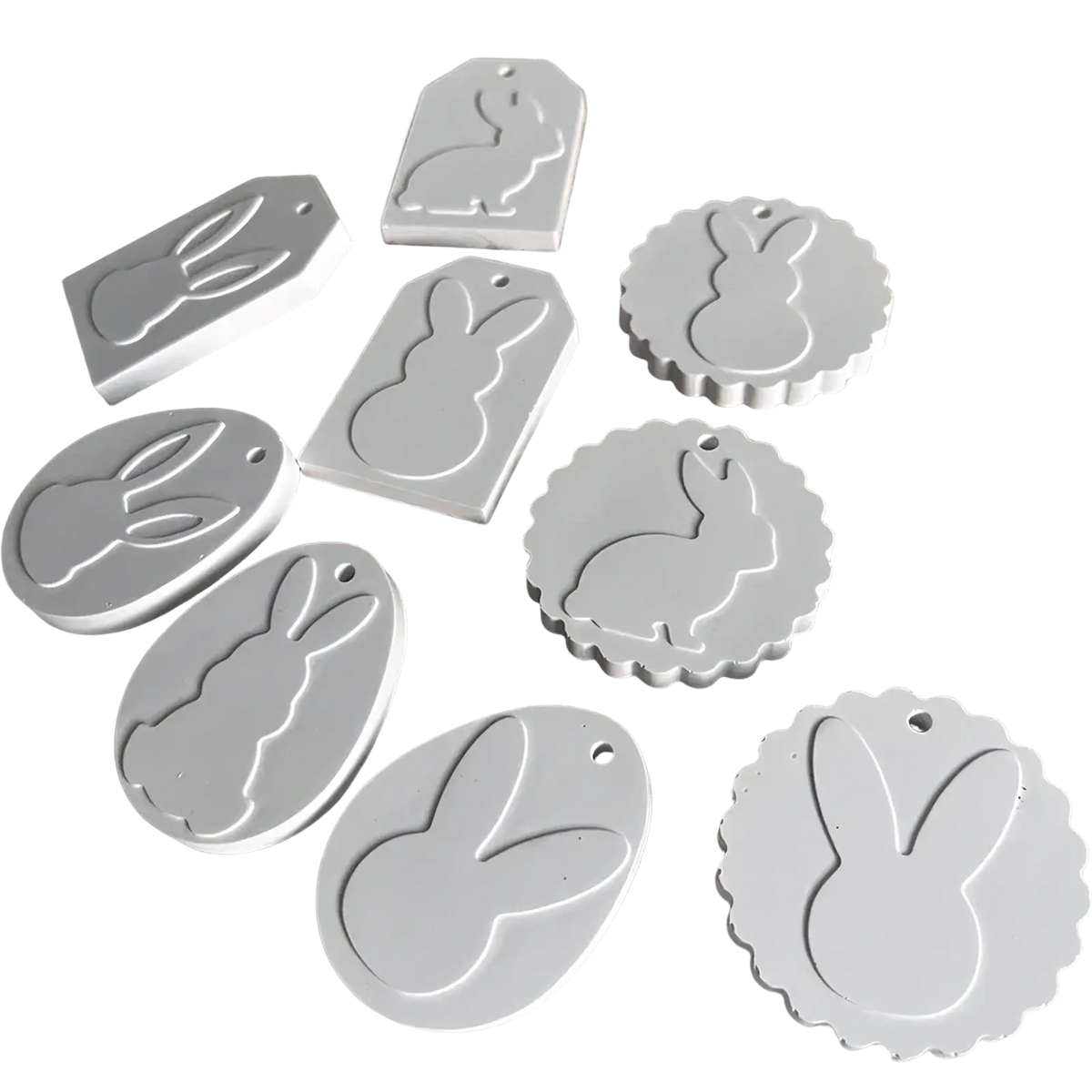 White bunny-shaped tags in various sizes made of smooth matte plastic from an easter bunny silicone resin pendant mold