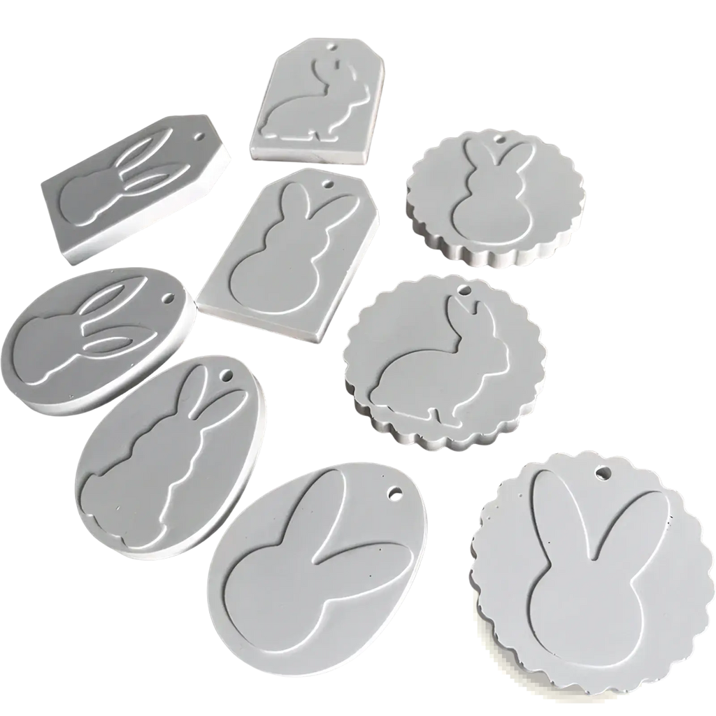 White bunny-shaped tags in various sizes made of smooth matte plastic from an easter bunny silicone resin pendant mold