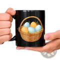 Black ceramic Easter egg coffee mug featuring a colorful woven basket illustration with blue and yellow eggs