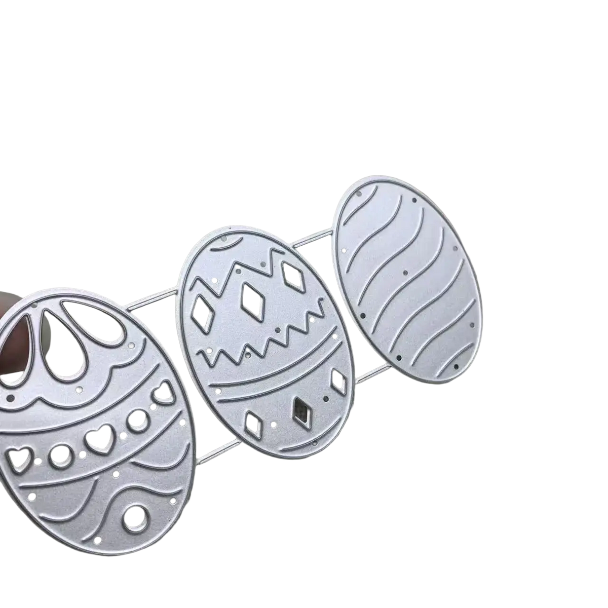 Set of three silver-toned metal easter egg-shaped die-cutting templates with intricate perforated patterns for card making