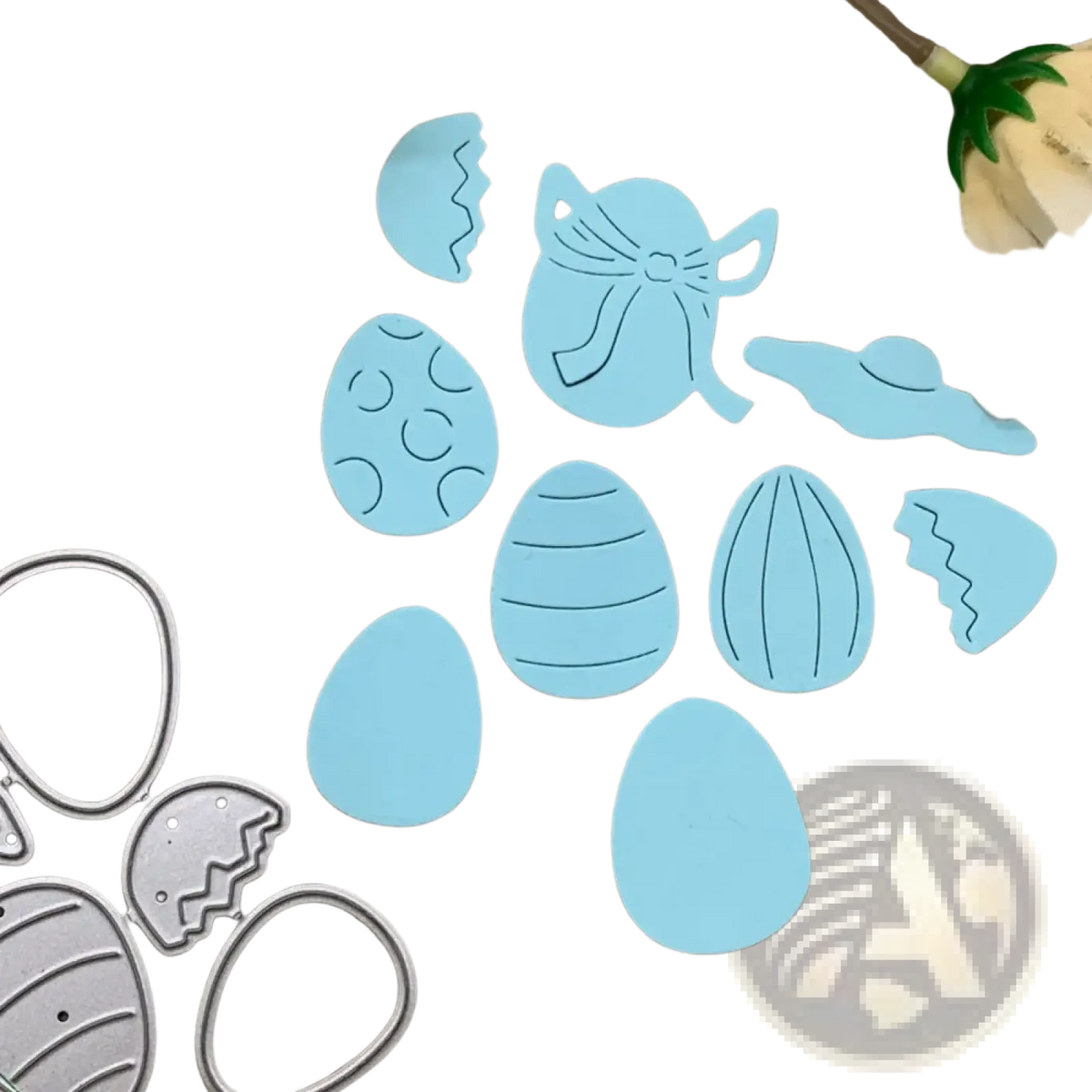 Light blue easter egg metal cutting dies and die cut shapes arranged on a textured surface for scrapbooking