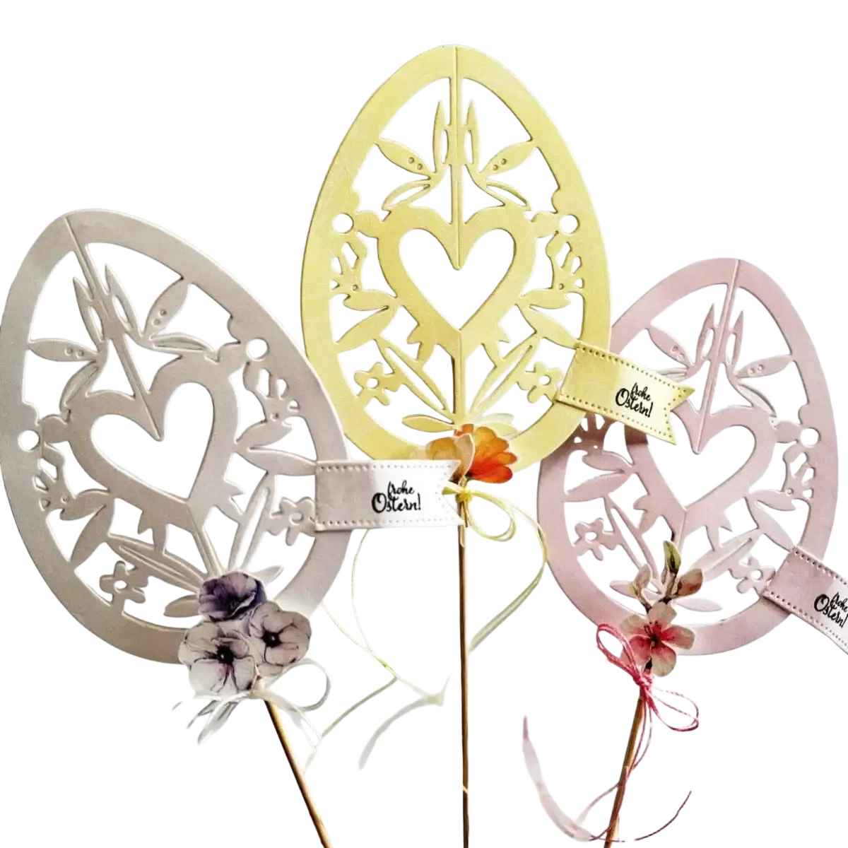 Three metallic floral and heart patterned easter egg cutting dies in cream pale yellow and soft pink for crafting