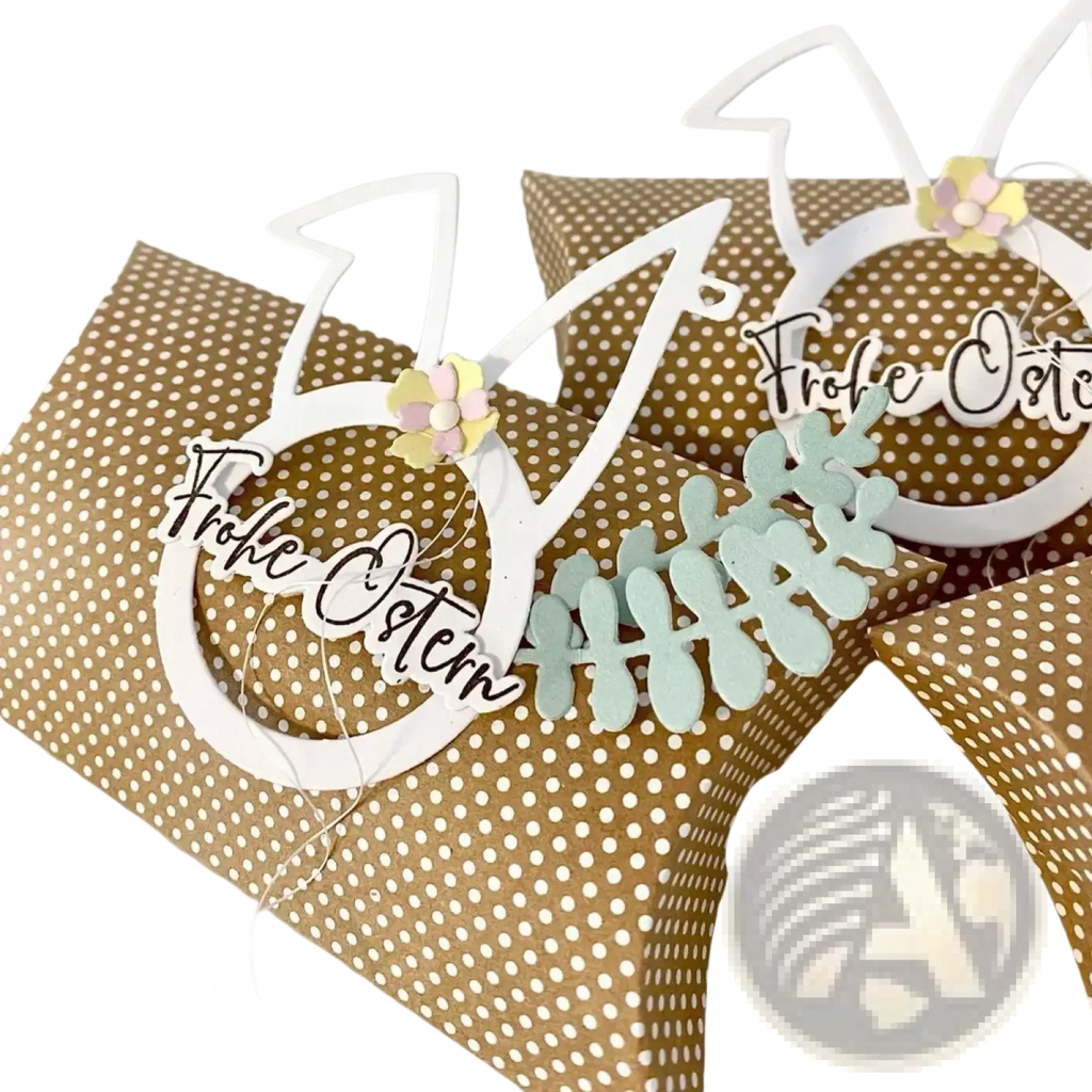 White paper bunny-shaped easter egg rabbit baby cutting die gift tag with frohe ostern script and pastel flower embellishments