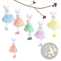 Pastel-colored plush bunny ornaments with lace-trimmed tutus and matching shoes hanging from strings in easter fairy set