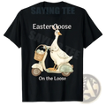 Black cotton t-shirt featuring a white cartoon goose riding a scooter with a basket of eggs labeled easter goose on the loose
