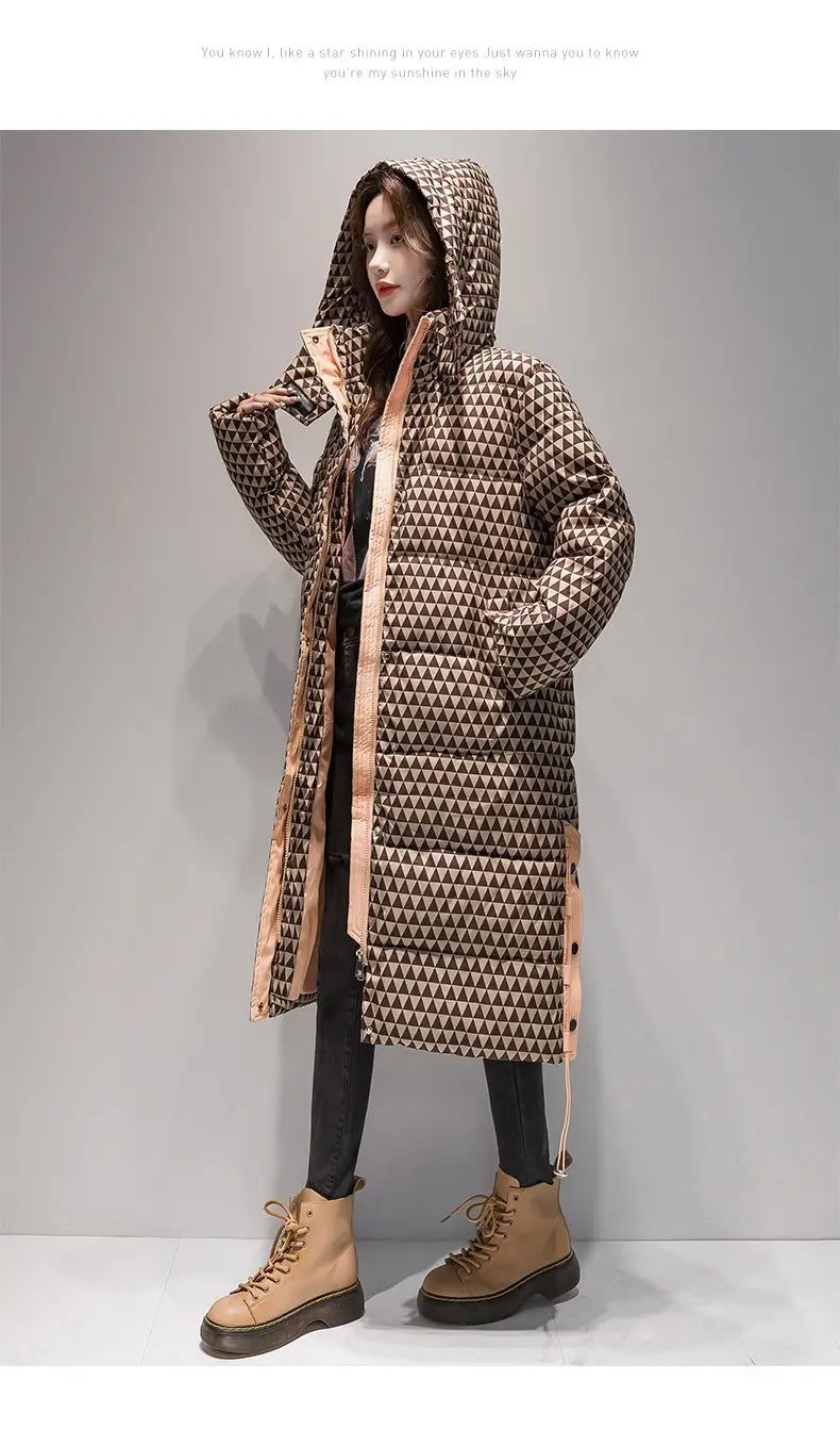 Manteau matelassé en coton à carreaux pour femmes avec un long design matelassé, un motif de triangle géométrique dans des tons de marron et de beige, une capuche, une fermeture à glissière à l’avant et une doublure intérieure contrastante de couleur pêche.