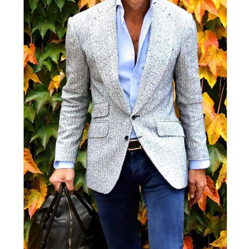 Herren-Karos-Blazer Slim Fit, taillierter Casual-Jackenschnitt aus grauem, strukturiertem Stoff mit einem dezenten gesprenkelten Muster, über ein hellblaues Hemd mit Knopfleiste getragen.