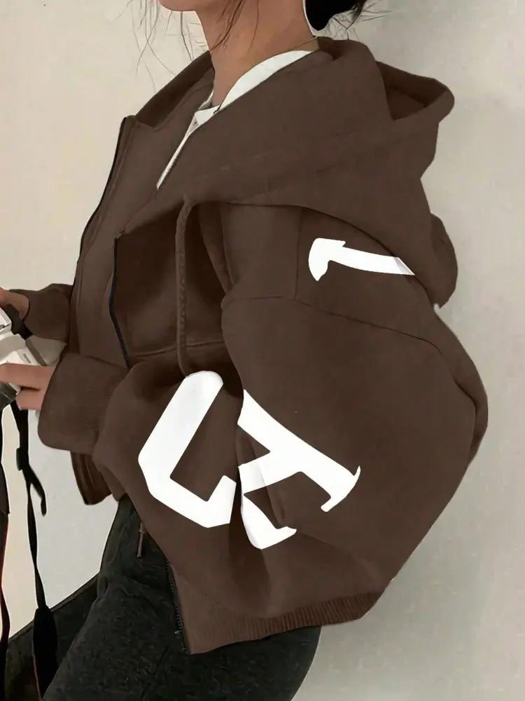 Sweat-shirt à capuche zippé imprimé graphique marron court, avec des lettres blanches audacieuses sur les manches, en tissu confortable