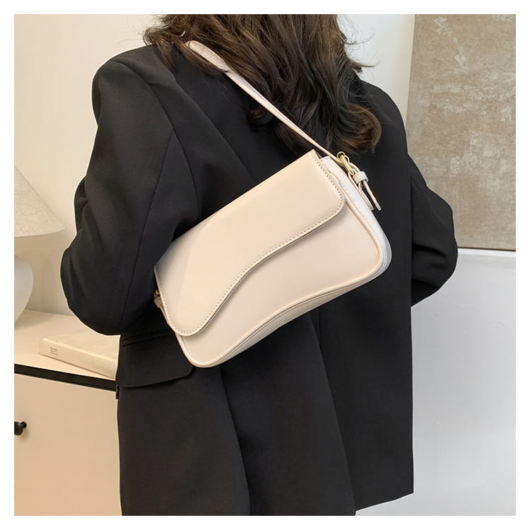 Cream-colored leather messenger bag with smooth leather-like material and a sleek minimalist crossbody design for everyday use.