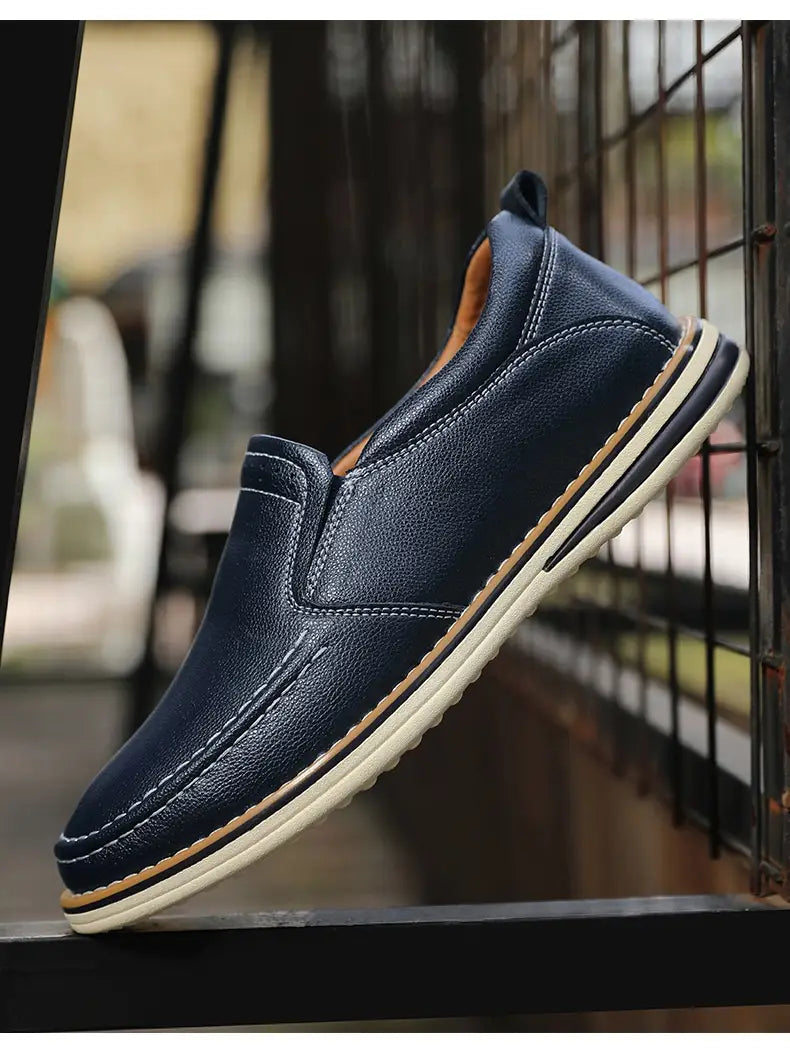 Dunkelblaue Lederschlupf-Loafer mit weißen und beigen Akzenten, handgenäht für den legeren Gebrauch.