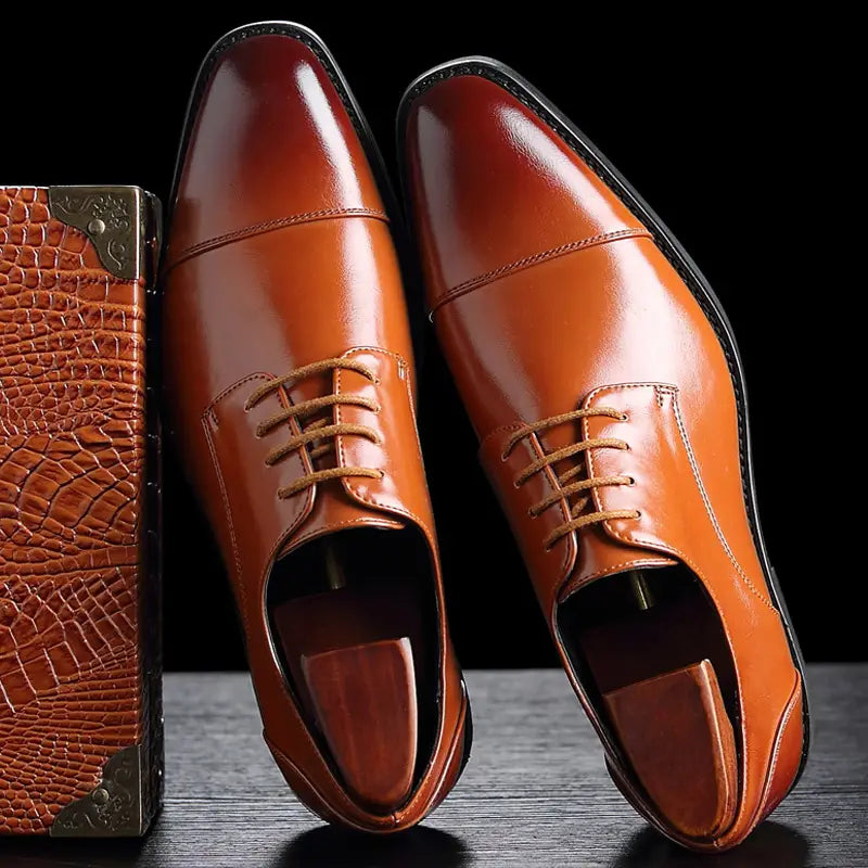 Herren-Businessschuhe im britischen Stil mit spitz zulaufender Zehenpartie aus Kunstleder, poliertes Braun mit beigen Schnürsenkeln und klassischem Kappenzehen-Design.