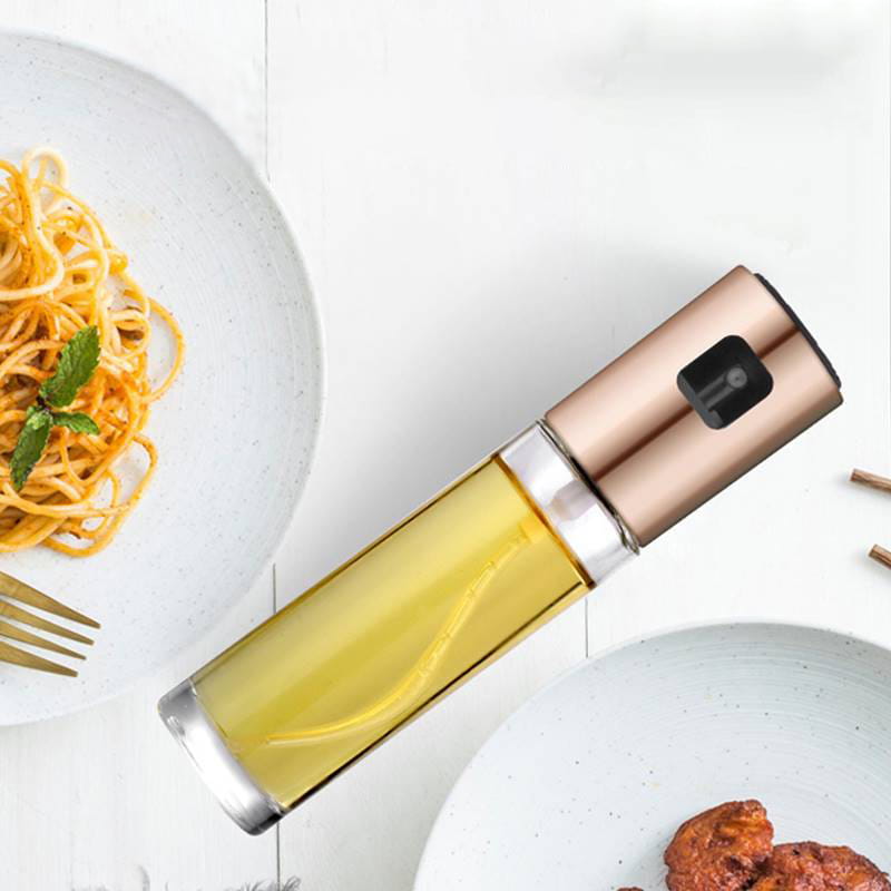 Eine elegante Roségold-Ölsprühflasche zum Kochen mit einem klaren Glasgehäuse, gefüllt mit goldenem Öl und einem auslaufsicheren Glassprayer.