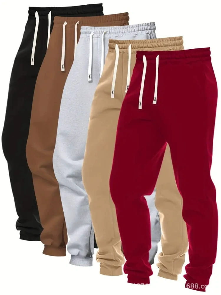Men’s 5-pack solid jogger pants featuring a set of five sweatpants in black brown white beige and red with matching drawstrings and a small x logo.