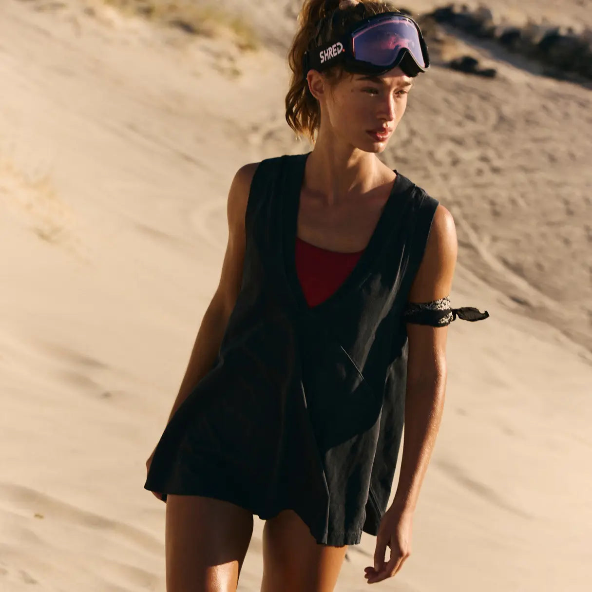 black sleeveless cotton wrap vest top with red inner lining and adjustable straps worn over a matching black top