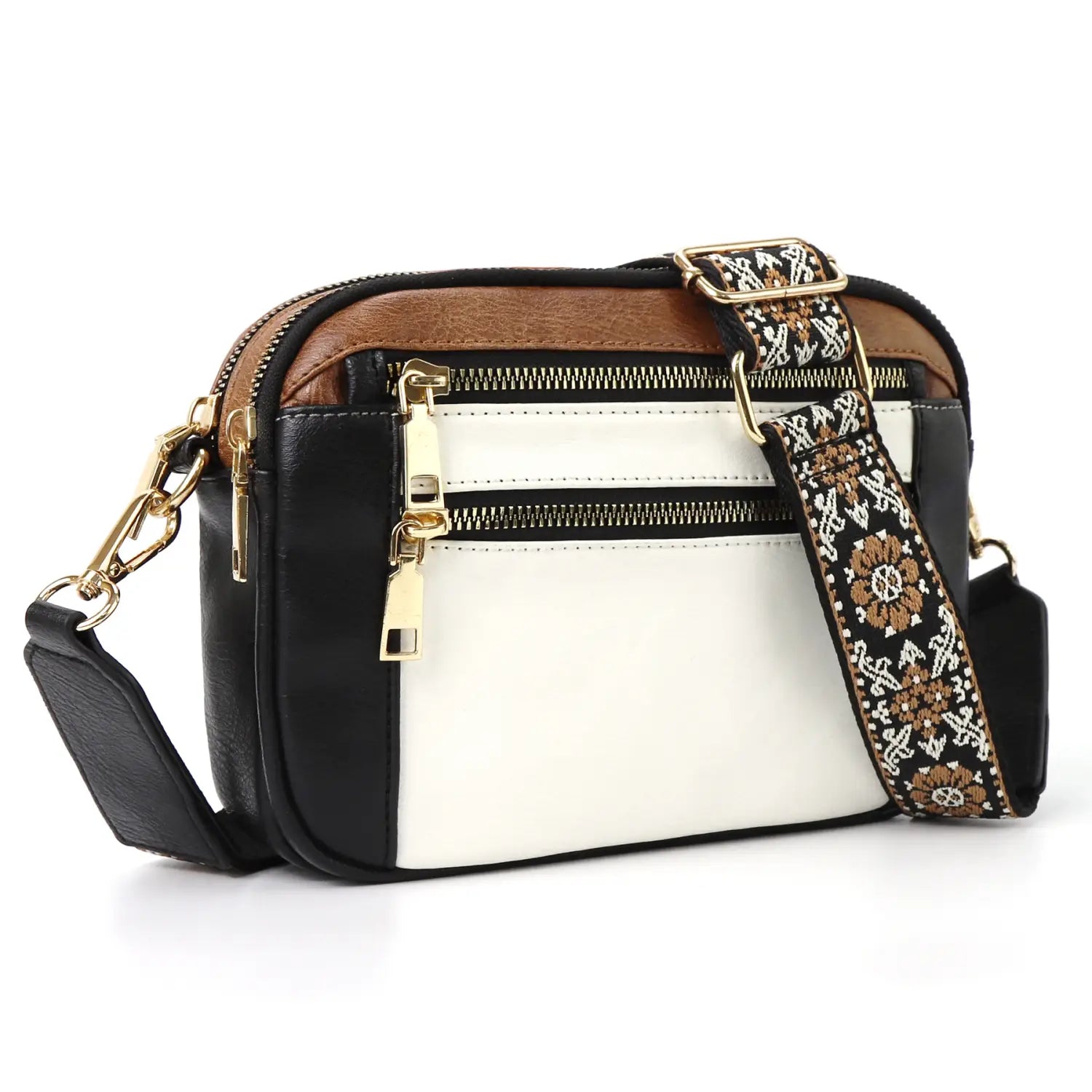 A stylish triple zipper floral strap colorblock crossbody bag with black white and brown panels featuring gold-tone zippers and an ornate patterned strap.
