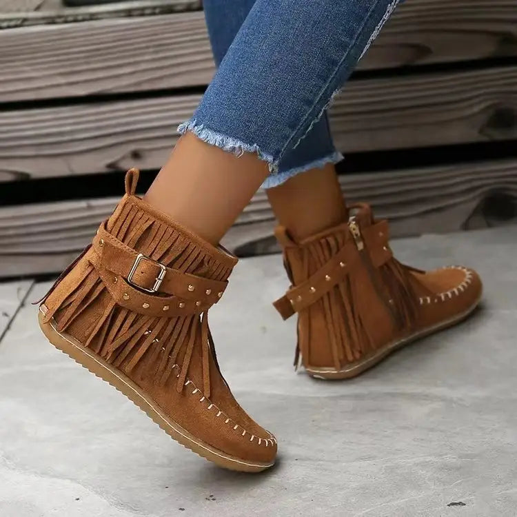 Botines retro de ante color camel con flecos, correas con tachuelas y detalle de hebilla plateada.