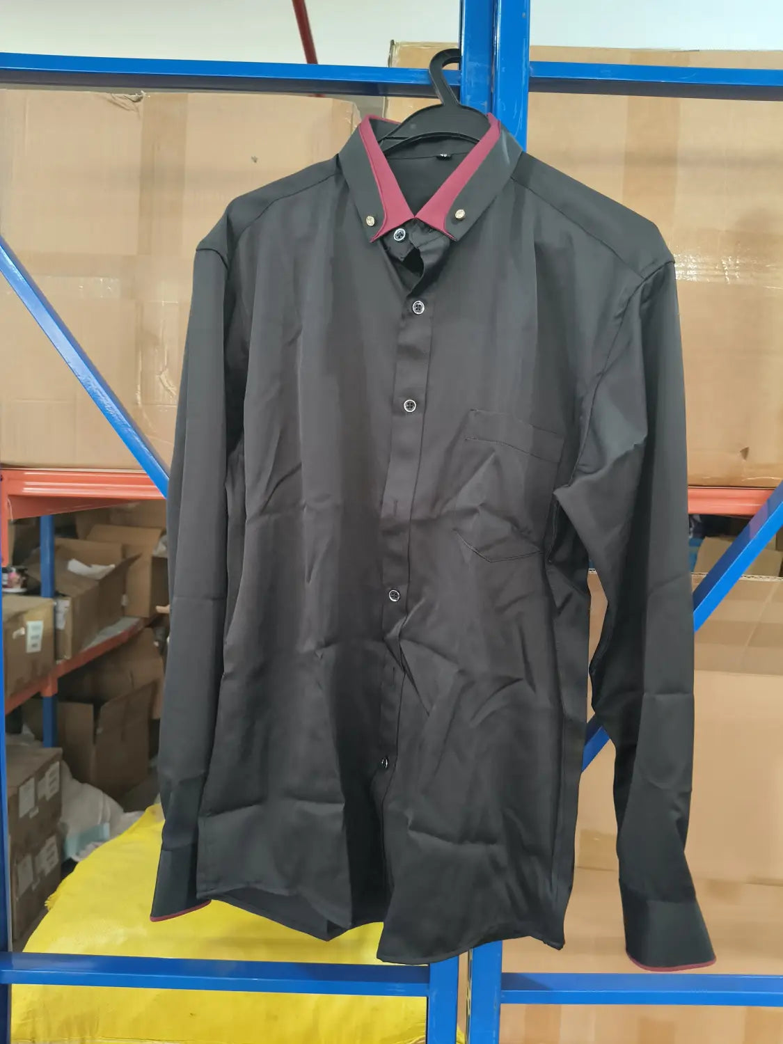 Herren Stretch-Anzughemd mit Kontrastkragen in Schwarz, mit rotem Kragen und passendem rotem Besatz an den langen Ärmeln, ordentlich an einem Bügel hängend.