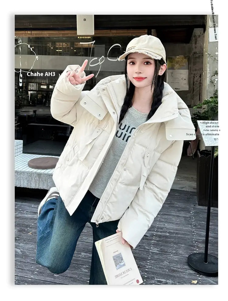 Veste courte matelassée à capuche pour femme couleur crème, avec design matelassé et fermeture éclair frontale, conçue pour l’habillement d’hiver chaud.