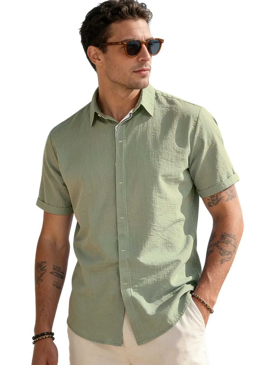 A men’s short-sleeved button-up shirt in light olive green made from textured bamboo linen fabric with subtle vertical pleats and neatly folded cuffs.