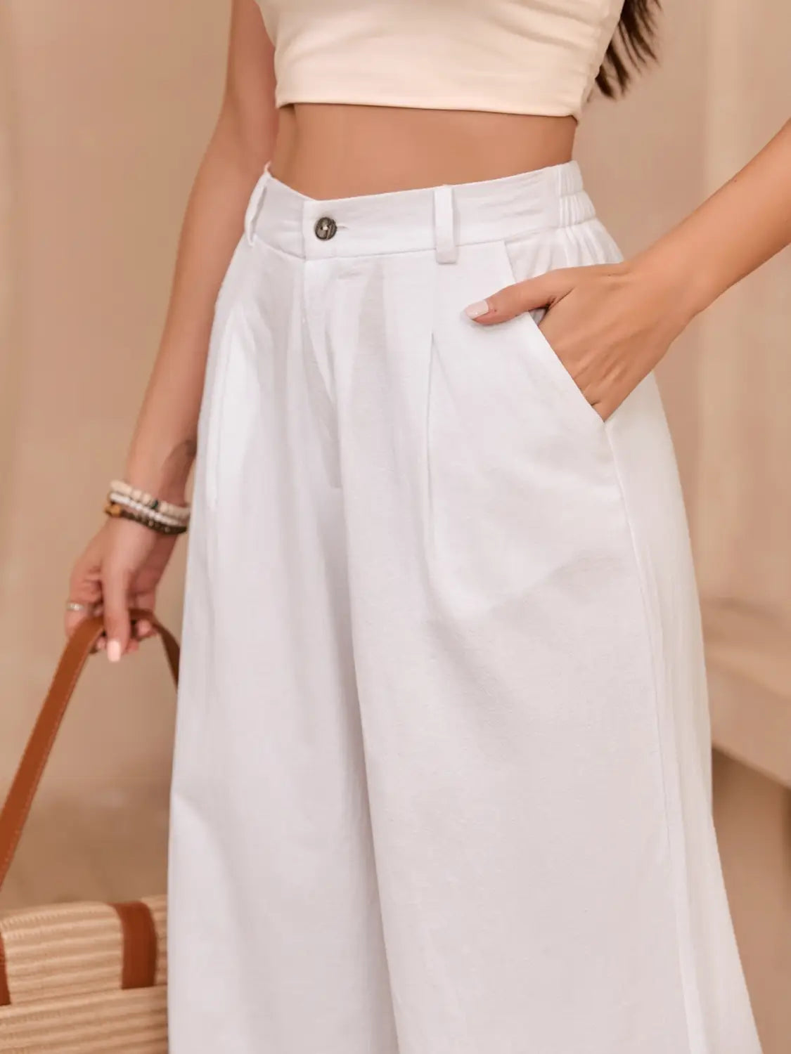 White linen high waisted wide leg pants with a minimalist design and subtle front pleats.