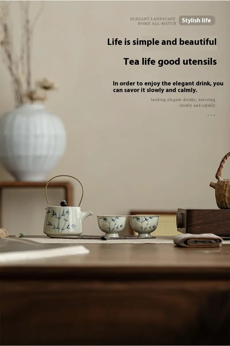 White ceramic blue bamboo ceramic teapot set with two cups featuring delicate green bamboo leaf patterns.