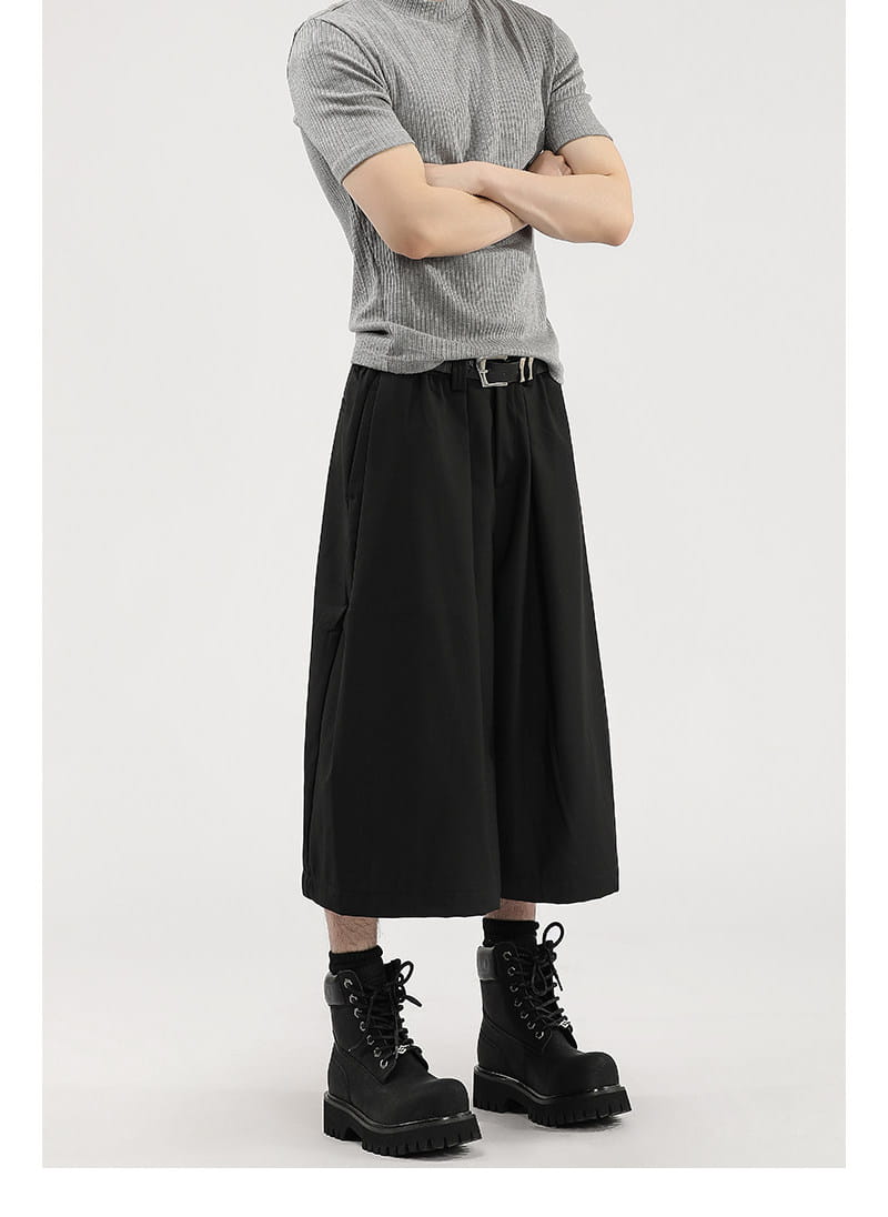 Short de costume pour hommes à jambes larges plissées noir, avec une silhouette fluide décontractée et des plissés discrets au niveau de la taille.