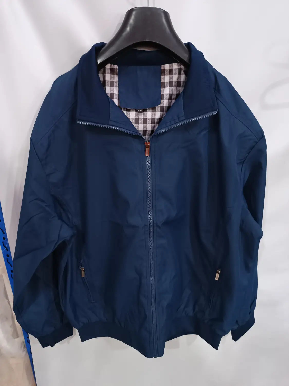 Veste bombardier légère pour homme bleu marine, avec fermetures éclair argentées et doublure à carreaux, conçue pour un usage décontracté.