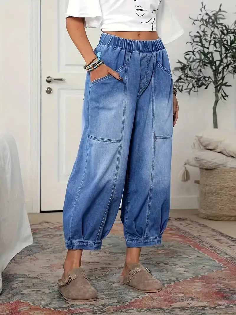 Pantalon capri en denim bleu clair à taille haute, avec une ceinture élastique et des jambes larges resserrées vers le bas.