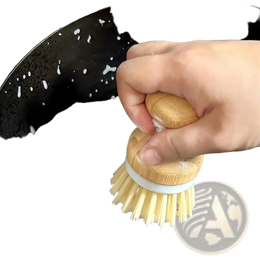 Eco friendly kitchen brush set with natural wood handle, light yellow bristles, and white band cleaning a soapy pan
