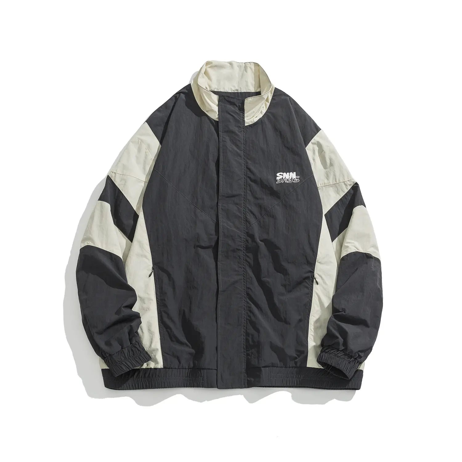 Veste coupe-vent ample à blocs de couleurs noir et beige, avec un logo brodé discret sur la poitrine.