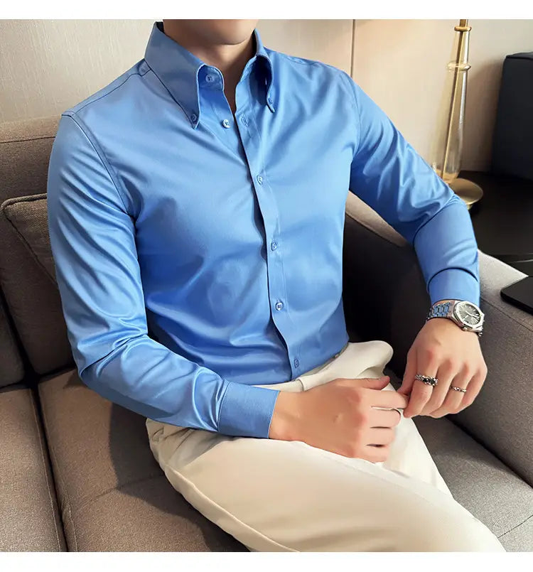 Chemise habillée sans repassage pour homme en grande taille en bleu clair lumineux, col classique et tissu boutonné manches longues soigneusement repassé.