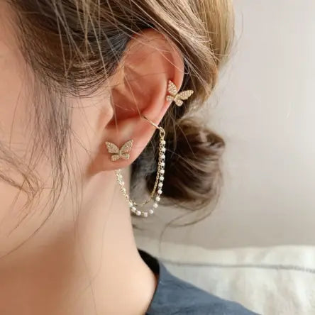 Gold-toned butterfly-shaped ear cuffs adorned with sparkling rhinestones and a delicate pearl chain from the Butterfly and Diamond Alloy Earring and Ear Cuff Set.