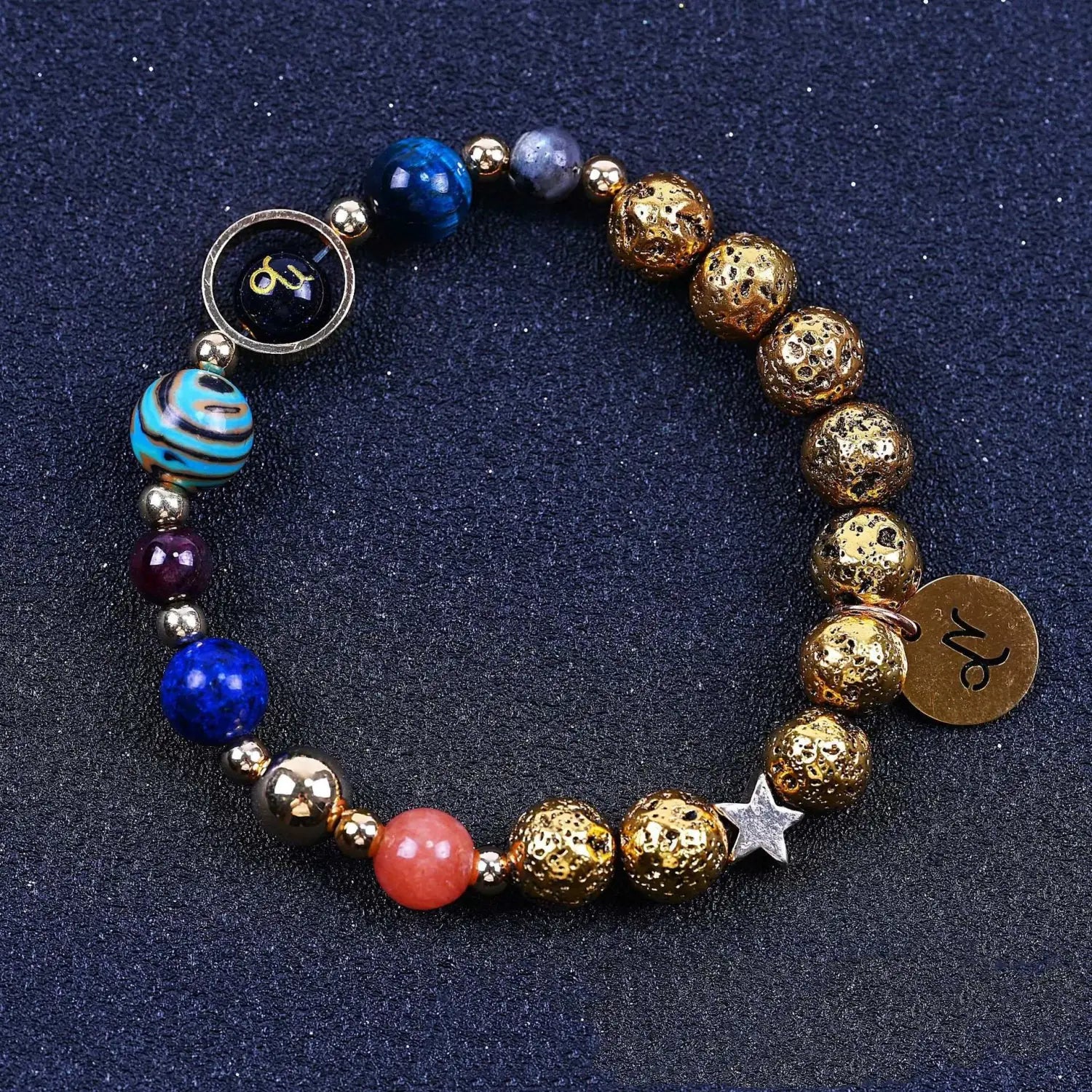 A colorful stretchy zodiac volcanic stone beaded bracelet featuring gold-toned lava stone beads, vibrant blue and red gemstones, a turquoise striped bead, silver star charm, and zodiac sign charms.